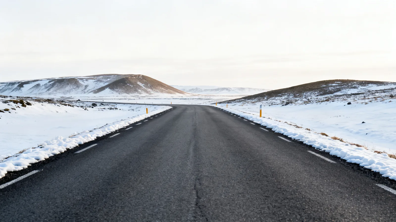 Anonymous rural Icelandic road with snow along the verges