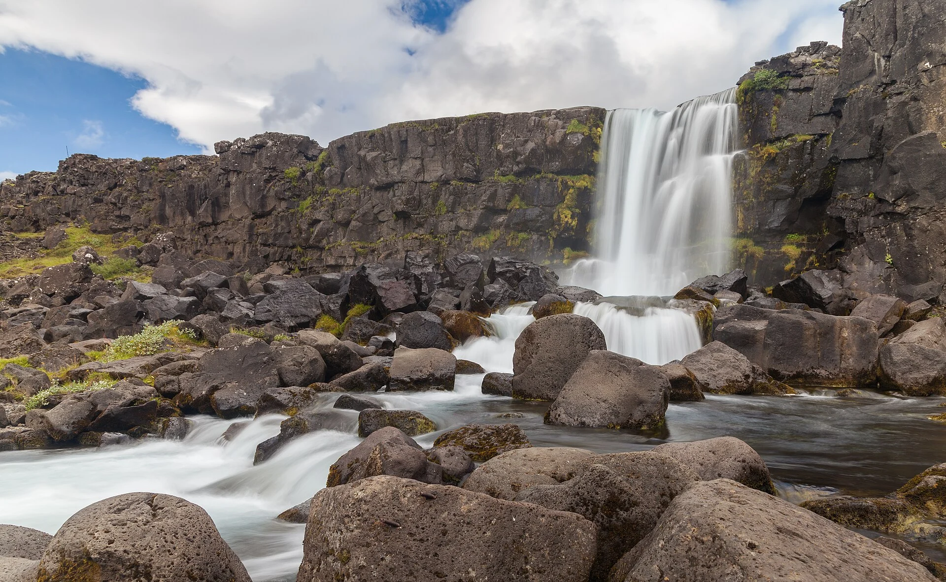 Öxarárfoss waterfall dropping over dark rock at Þingvellir